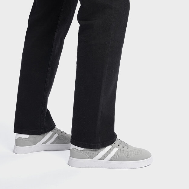 Ben med svarte bukser og grå sko med hvite detaljer