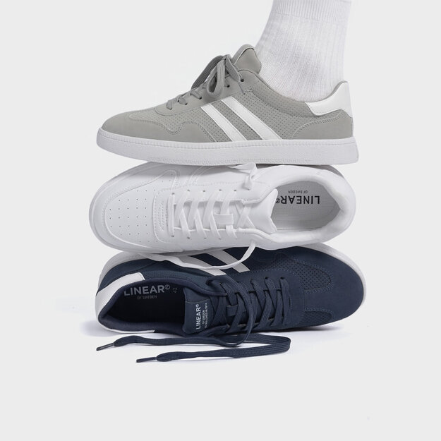 Ben med svarte bukser og grå sko med hvite detaljer